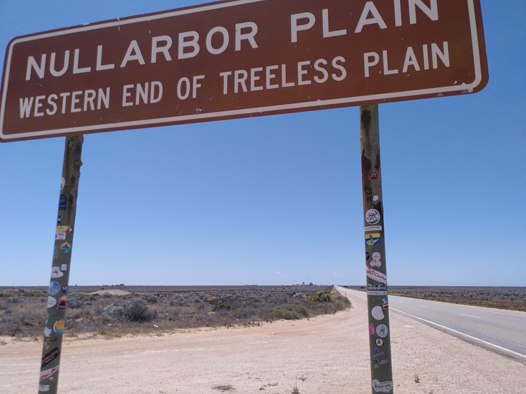 purplecon stickers on a sign in the middle of absolutely nowhere, on a trail to the nullabor plain